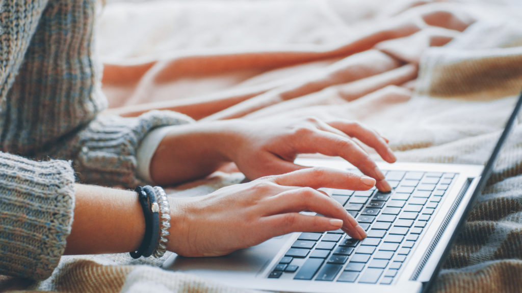 Photo of a woman's hands typing on a laptop